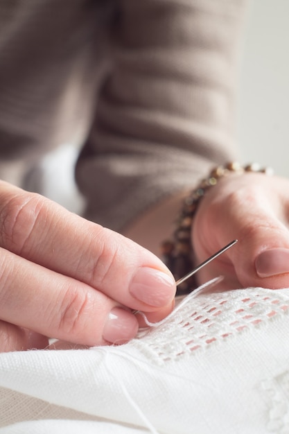 Mâini brodând detaliu